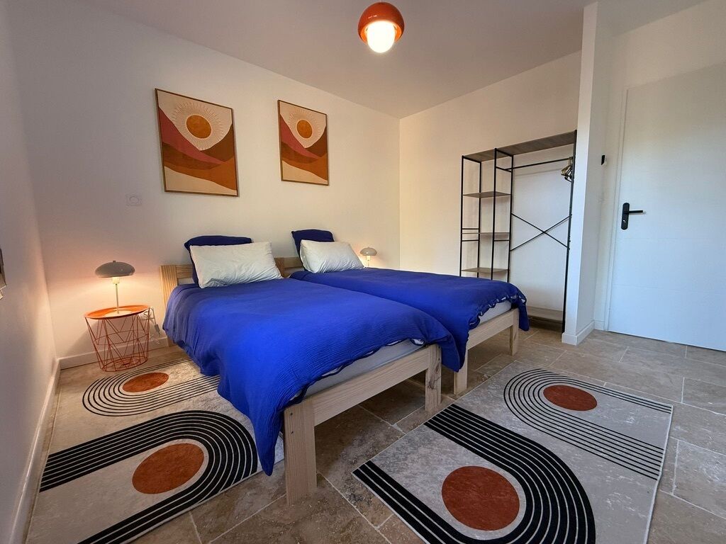 A bedroom with two beds, a wardrobe, and a bathroom.