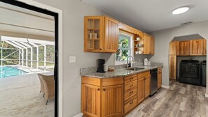 Una cocina con armarios de madera, encimeras de granito y lavavajillas integrado.
