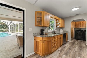 Una cocina con armarios de madera, encimeras de granito y lavavajillas integrado.