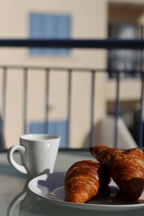 A table with a plate of croissants and a white cup. - 06 KPF - Stay Vera s Apartment (Paphos)