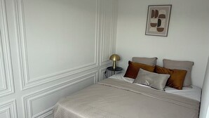 Une chambre à coucher avec un lit, une table de chevet, une lampe et un tapis.