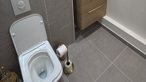 Une salle de bain moderne avec des toilettes, un lavabo et un miroir.