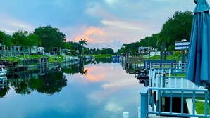 A calm water body with a wooden dock, boats, and RVs docked on the left. - Luxury rv lot 191 at River ranch rv resort golf cart included  NO RV INCLUDED (Lake Wales)