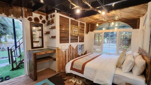 Une chambre à coucher rustique avec un grand lit, des murs en bois et une vue sur l’extérieur.