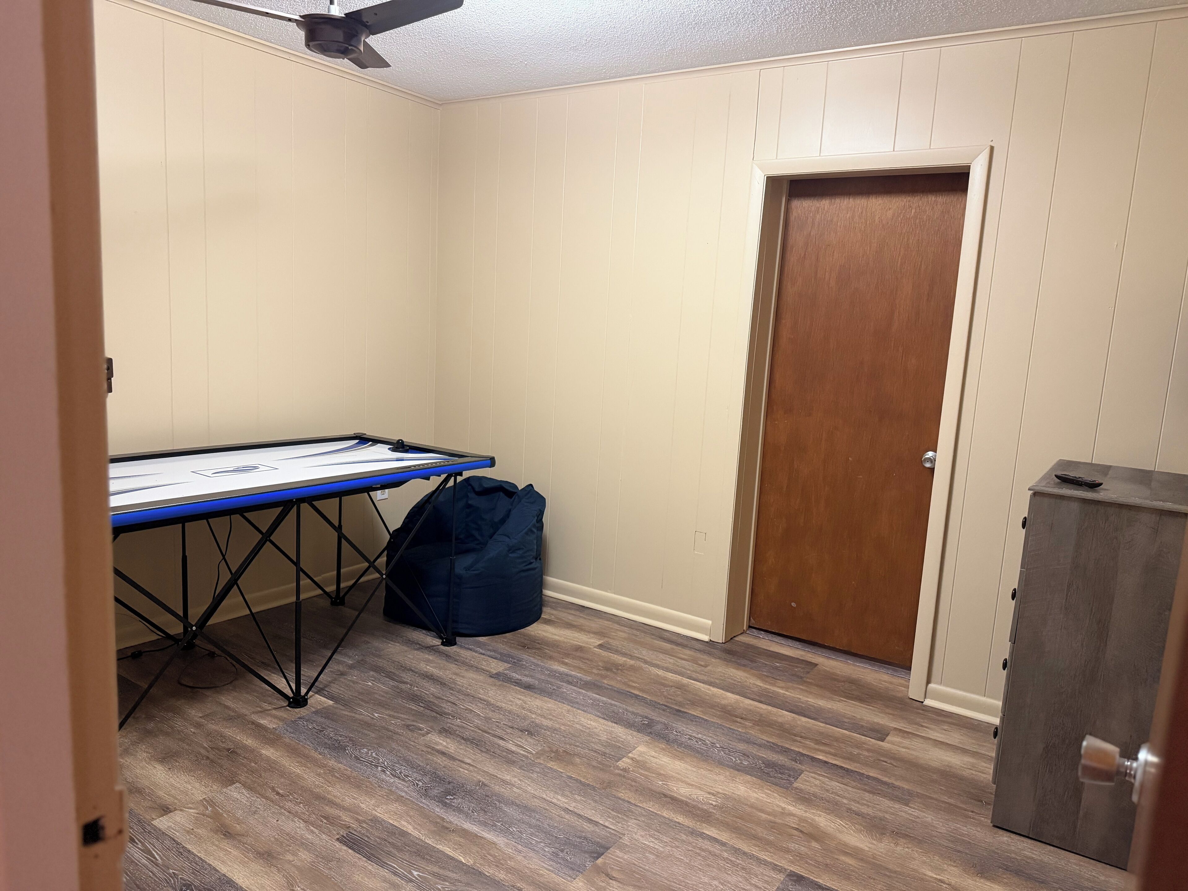 Une pièce avec une table de ping-pong, une porte et un placard.