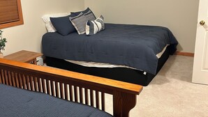 A bedroom with two beds, a wooden bench, a small table, and a door. - Perfect 3-bedroom condo in beautiful Lake Placid for your getaway (Lake Placid)
