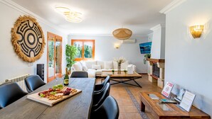 Un coin repas avec une table en bois, des chaises et un plateau de fruits.