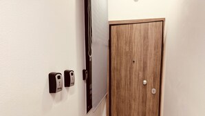 Ein Flur mit einer Holztür und einem an der Wand montierten Gegensprechanlage.