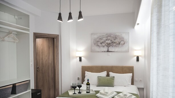 Ein modernes Schlafzimmer mit Bett, Nachttischen, einem Schreibtisch und einer Pendelleuchte.