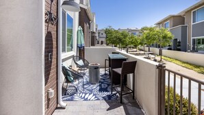 A balcony with outdoor furniture, a trash can, and a street view. - Spacious, Family-friendly Chula Vista 3BR + Children's Playroom+Pool & Park (Chula Vista)