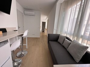 Una sala de estar moderna con un sofá, un comedor y una cocina.