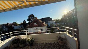 A balcony with a view of houses, a potted plant, and a hanging light fixture. - 300m to the fine Baltic Sea beach - Comfort vacation apartment Seemöwe Scharbeutz (Scharbeutz)