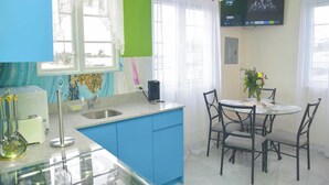 Una cucina con un piano di lavoro blu, un lavello e un'area pranzo con tavolo e sedie.