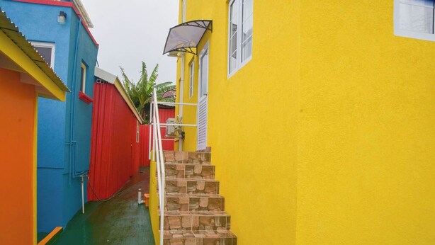 Un stretto vicolo con una scala che conduce a un edificio giallo.