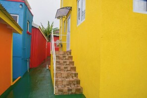 A narrow alleyway with a staircase leading up to a yellow building. - Grateful #2 1&2 BDS APT, CAR RENTALS Available (Bridgetown)