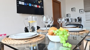 Een eettafel met borden, glazen, een karaf en een schaal druiven.