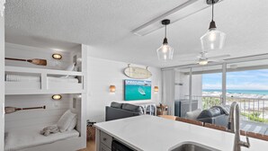 Cozinha moderna com uma ilha grande, assentos embutidos e vista para a praia.