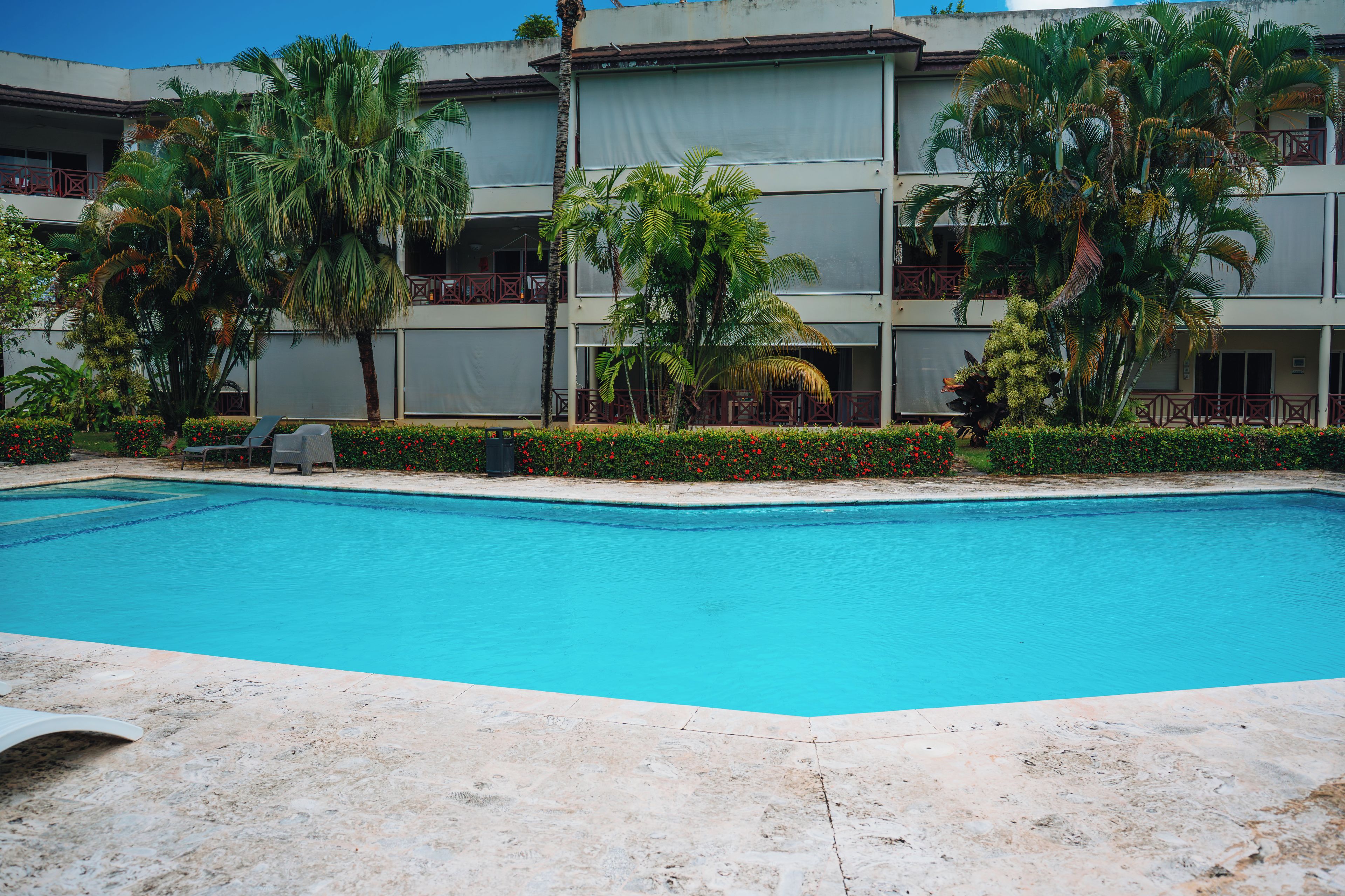 Une piscine à l’eau d’un bleu cristallin, entourée d’une terrasse carrelée.