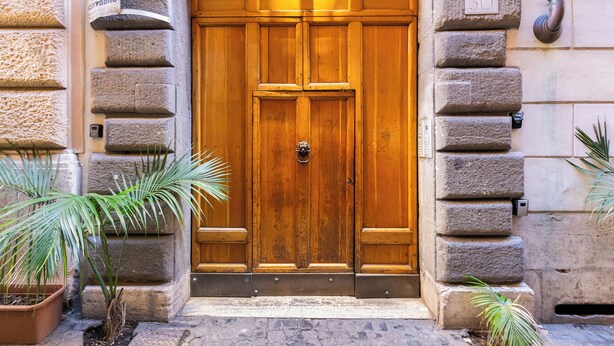 A wooden double door with a metal handle, flanked by stone pillars, and a 'no parking' sign above. - PIAZZA NAVONA ADORABLE APARTMENT (Roma)