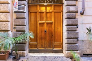 A wooden double door with a metal handle, flanked by stone pillars, and a 'no parking' sign above. - PIAZZA NAVONA: A CHARMING APARTMENT (Roma)