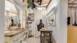 A cozy kitchen with a wooden countertop, a ceiling fan, and a dining area with a table and chairs. - PIAZZA NAVONA ADORABLE APARTMENT (Roma)