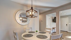 A dining area with a round table, four chairs, a hanging light fixture, and a large mirror on the wall. - Spacious 4-bedroom house in tranquil Decatur with AC (Decatur)