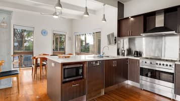 Una cocina moderna con una isla central, electrodomésticos de acero inoxidable y suelo de madera.