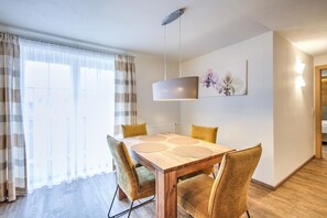 Un coin repas avec une table en bois, quatre chaises et un luminaire suspendu.