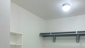A corner closet with white walls, a ceiling light, and a metal shelf unit. - Built in 2025 - In the heart of Lubbock (Lubbock)