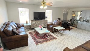 A living room with a sofa set, a coffee table, a TV, and a dining area with a table and chairs. - Built in 2025 - In the heart of Lubbock (Lubbock)