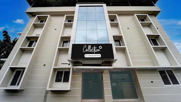 Un edificio moderno con una amplia fachada de vidrio, varios balcones y un letrero que indica que es un lugar de servicios empresariales.