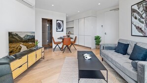 Een moderne woonkamer met een bank, een salontafel en een eethoek met stoelen en een tafel.