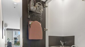 A compact laundry room with a Bosch washing machine, a drying rack, and a small sink. - Fitzroy North 1-bed With Balcony by Edinburgh Park (Melbourne)