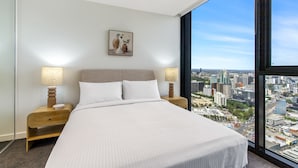 A modern hotel room with a large bed, two bedside tables with lamps, a city view, and a framed artwork on the wall. - Modern 1-bed in Hip Southbank With Pool & Gym (Melbourne)