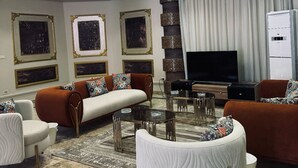 A modern living room with a sofa set, a coffee table, and a flat-screen TV. - فيلا للايجار اليومي خمس غرف مستقله (6 اكتوبر)