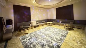 A modern lounge area with a patterned rug, seating arrangements, and a ceiling with a light fixture. - فيلا للايجار اليومي خمس غرف مستقله (6 اكتوبر)