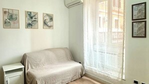 Ein Schlafzimmer mit einem Bett, einem Nachttisch und drei gerahmten Kunstwerken an der Wand.