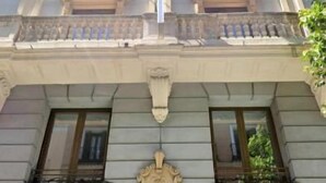 A multi-story building with a classical architectural style, featuring ornate detailing and a prominent central entrance with a door marked '19'. - Hostal Prada (Madrid)