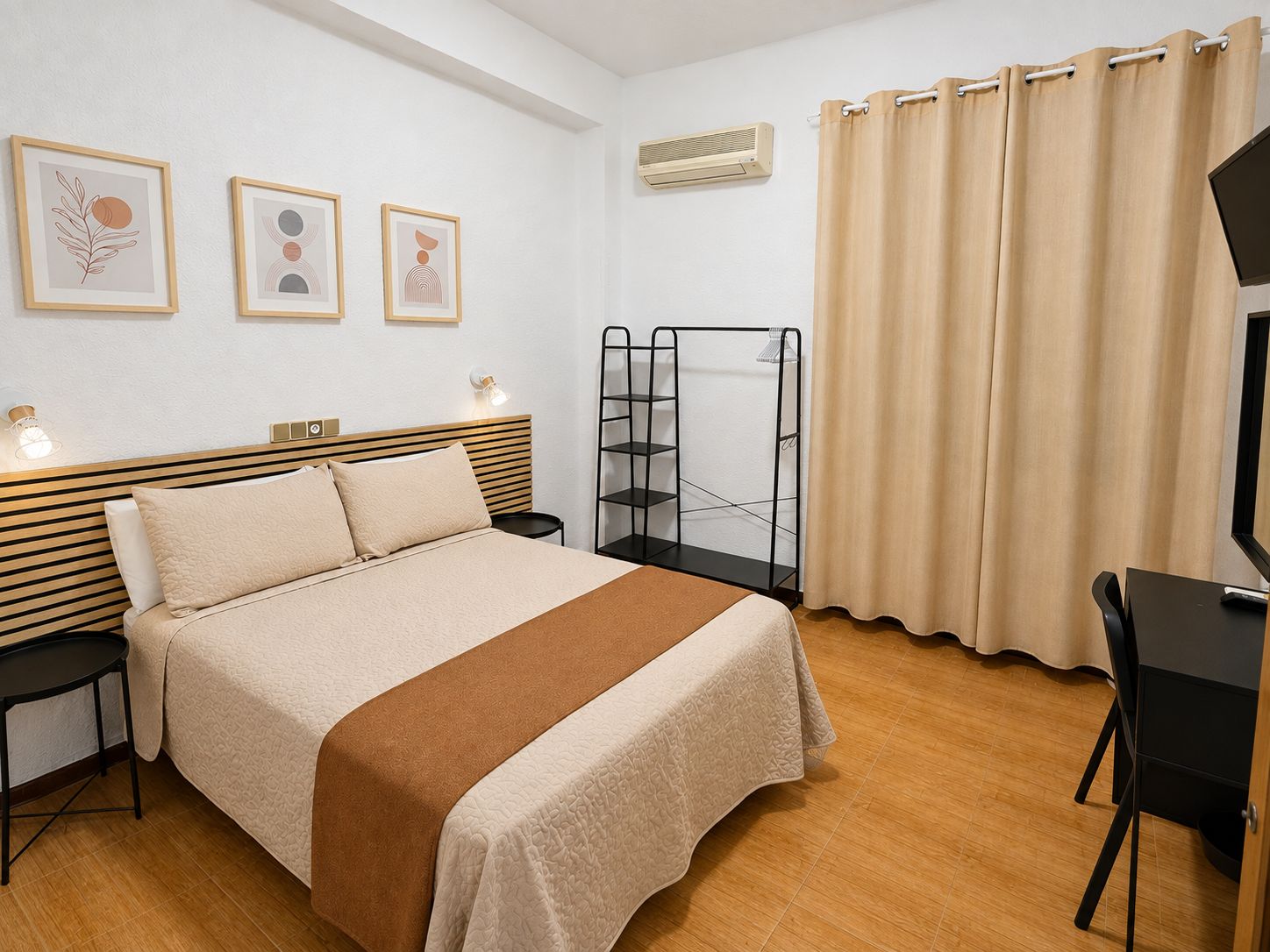 A neatly arranged bedroom with a bed, bedside tables, a wall-mounted air conditioner, a shelf unit, and a curtain.