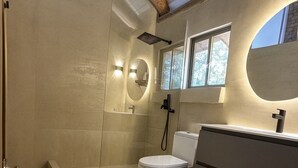 Un baño moderno con ducha, inodoro y tocador.