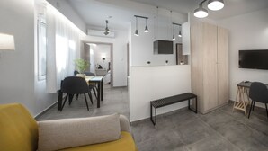 A modern living room with a sofa, a dining area with chairs, a bench, a TV, and a wooden wardrobe. - Athens Praxitelous Vibes (Athina)