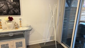 Una stanza con un armadio bianco, un vaso con fiori, una piccola statuina di Babbo Natale e un quadro raffigurante un orso appeso al muro.