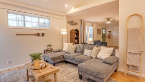 A spacious living room with a large sectional sofa, a wooden coffee table, and a small side table with a plant. - Walk to Main St & Swamp Rabbit Trail (Travelers Rest)