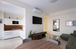 A modern living space with a kitchen, dining area, and a seating area.