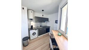 A compact kitchen with a washing machine, a sink, and a window. - La Verrière with its panoramic view! (Saint-Denis)