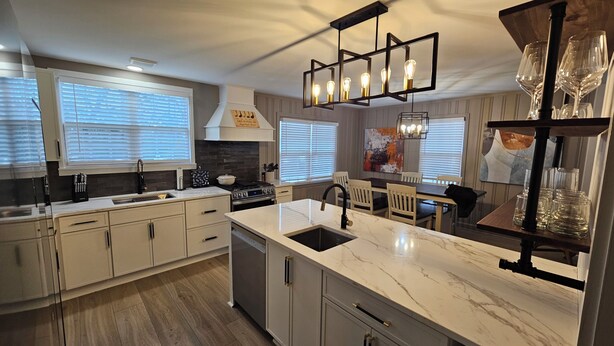 A modern kitchen with a marble countertop, stainless steel appliances, and a dining area with a wooden table and chairs. - Fabulous 3-bedrm In town/Masters 1 mle Bungalow new VRBO & SUPERhost on Air BB (Augusta)