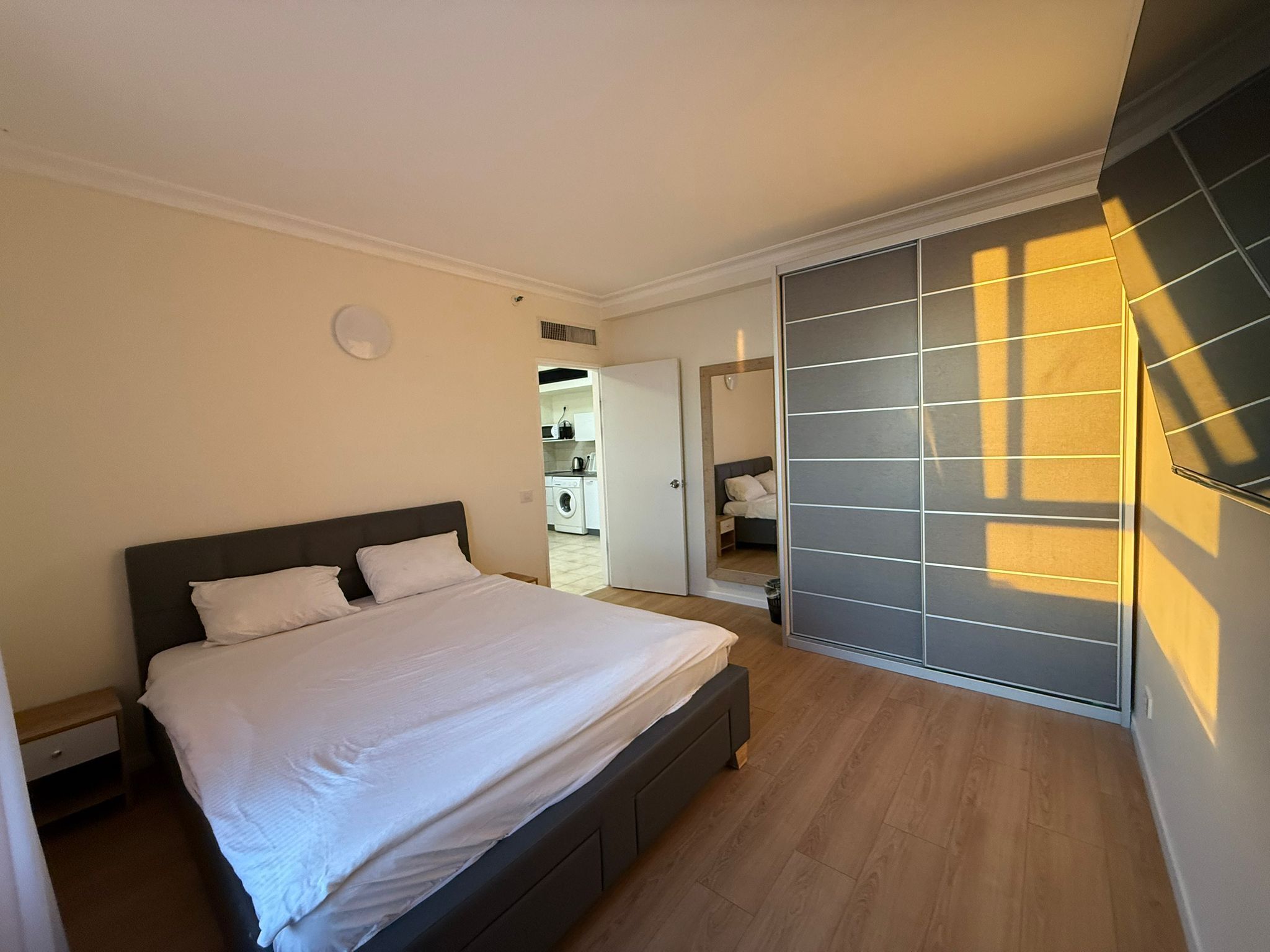 Une chambre avec un lit, une armoire et une vue sur une buanderie.