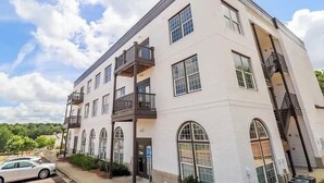 A multi-story building with a white facade, multiple windows, and a balcony on the second floor. - 2 miles from campus and the square.Cozy 2 BR/2BA in popular Rowendale community (Oxford)