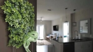A modern kitchen with dark cabinetry, a central island, and a hanging green plant. - 2 miles from campus and the square.Cozy 2 BR/2BA in popular Rowendale community (Oxford)