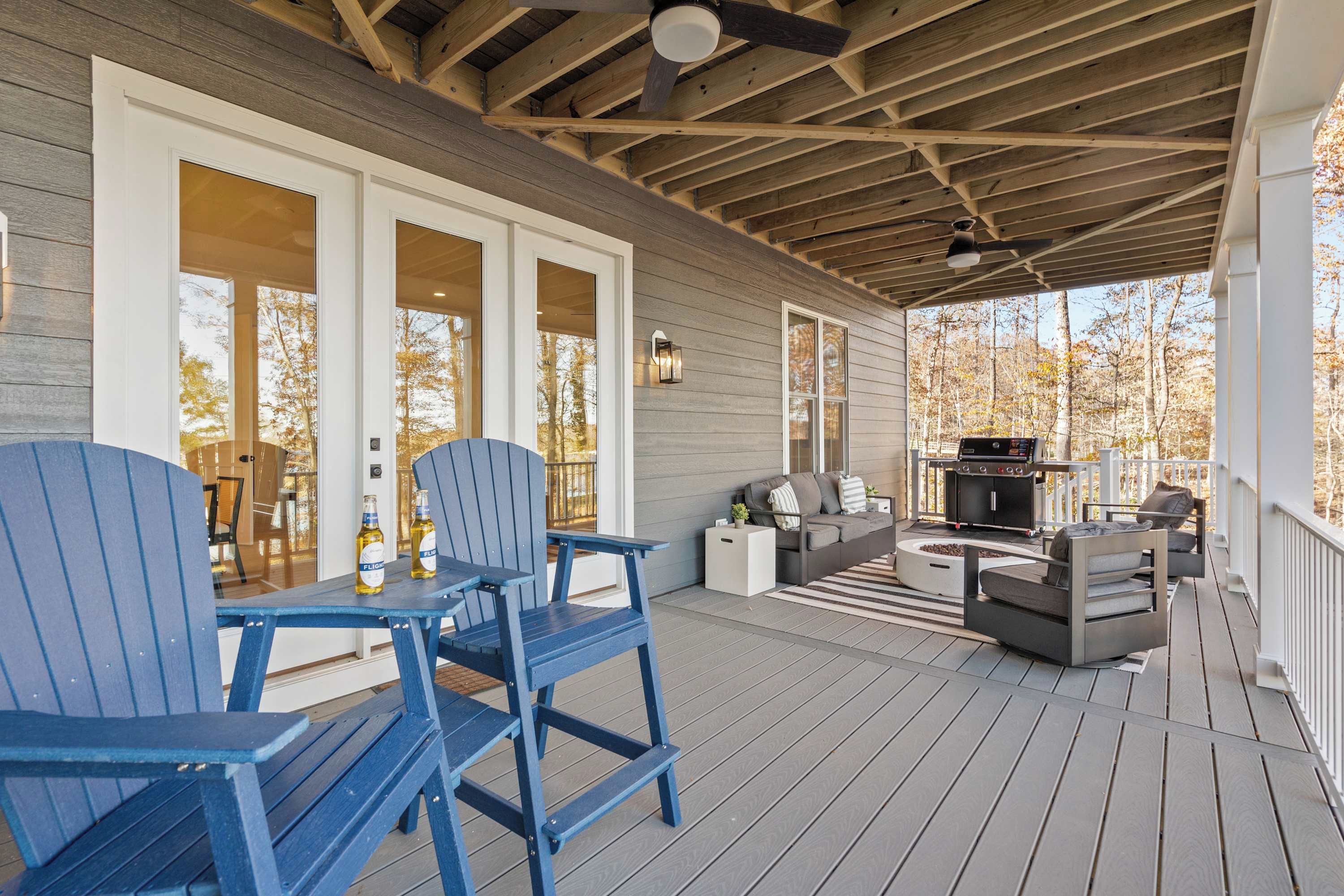 Lower Patio - Blue Adirondack bar chairs and a couch with a fire pit and grill make the lower deck perfect for evening cookouts.